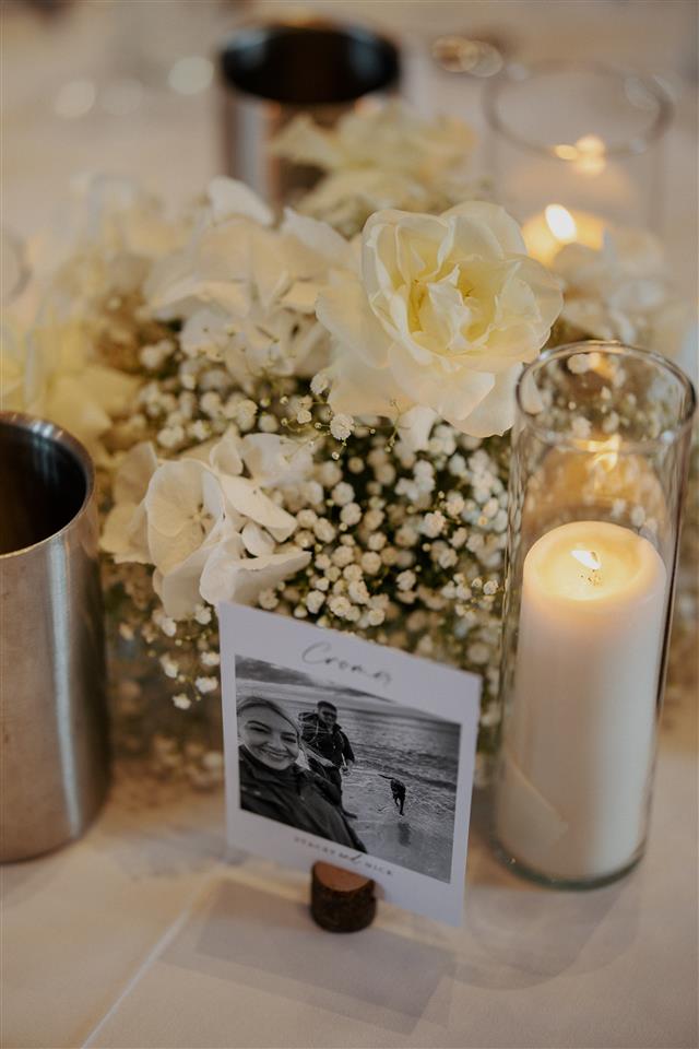 white table posy arrangement with candles in cylinder vases. Repurposed Aisle flowers to tables